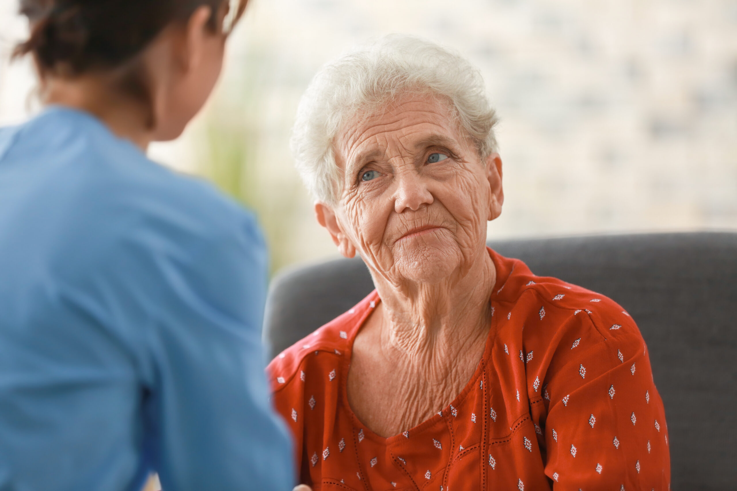 Young adultcare worker visiting elderly woman at home